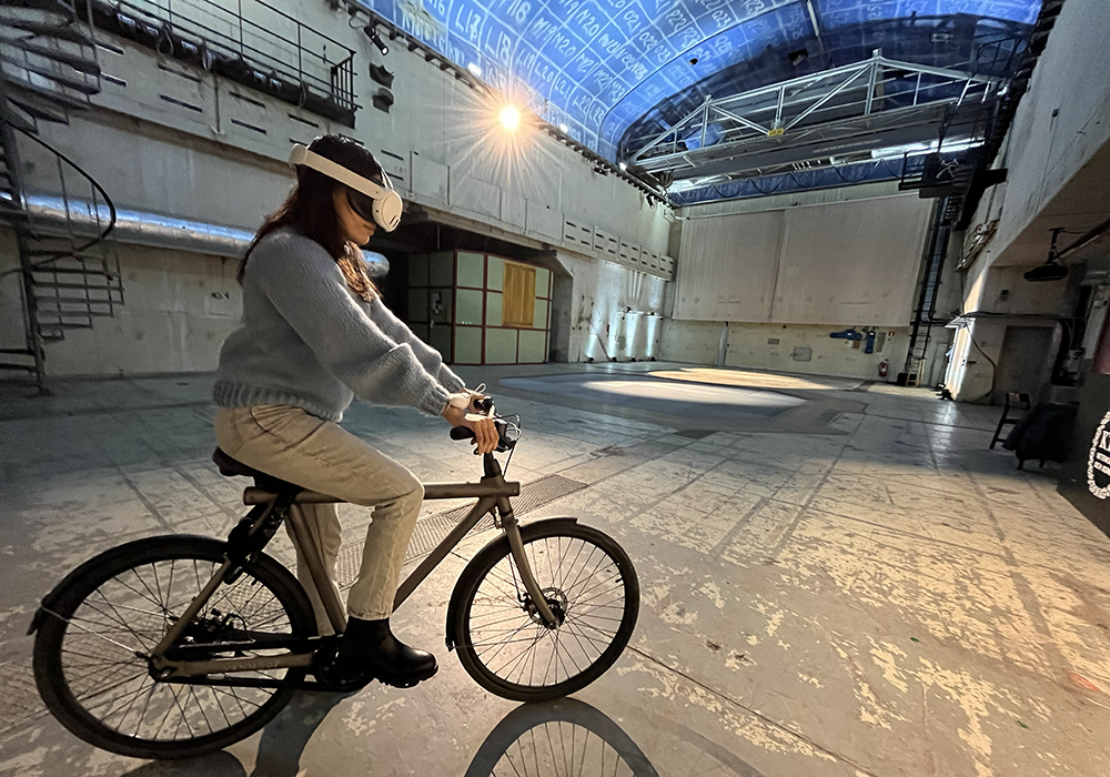 Person on bicycle in the R1 hall wearing AR goggles